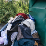 Tas de habits entasses contre un bac de tri