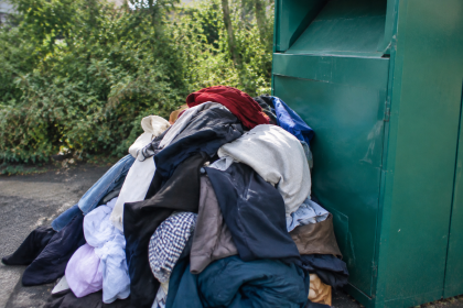 Tas de habits entasses contre un bac de tri