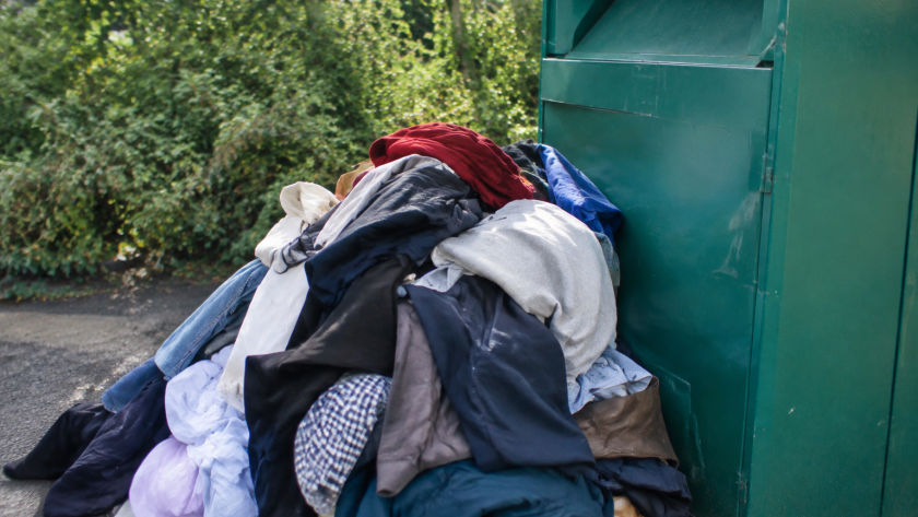 Tas de habits entasses contre un bac de tri