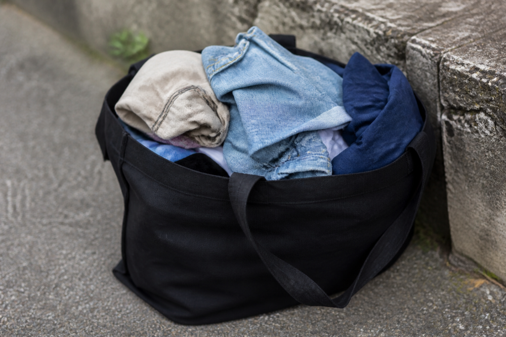 Vetements accumules dans sac solide noir